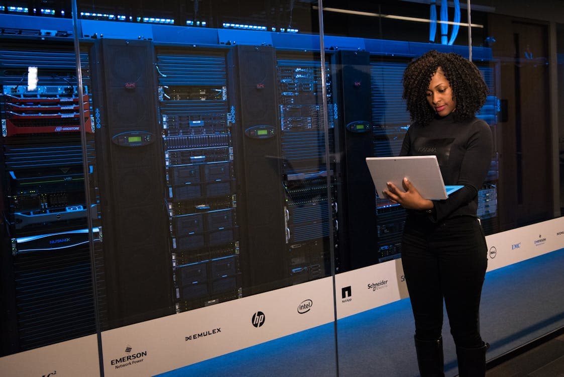 Software engineer standing beside server racks in a data centre